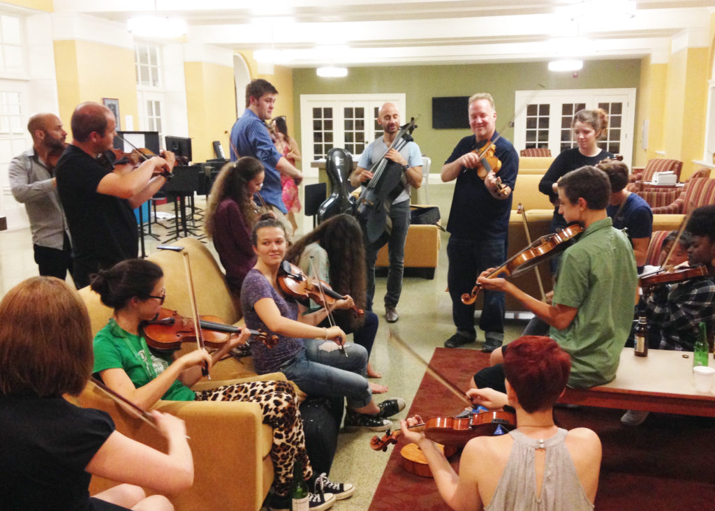 A group of people sitting around playing music.